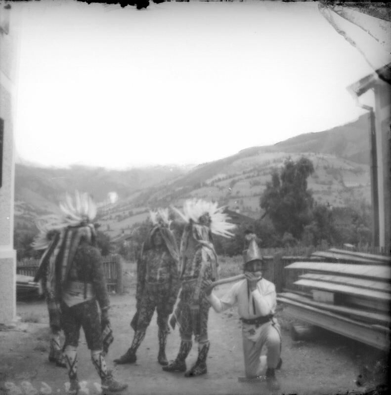 Fotografia d'epoca con figure mascherate dai grandi copricapi