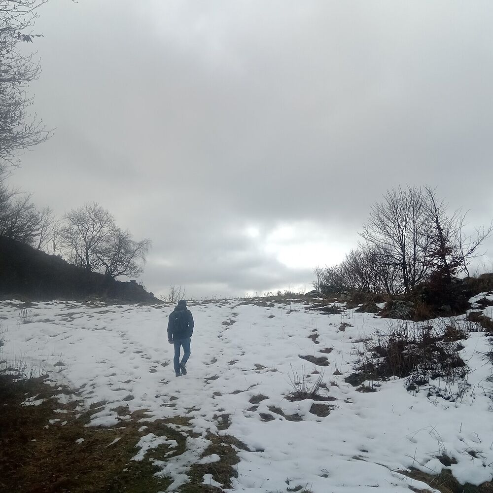 Una persona cammina sulle creste innevate sopra Fuipiano Valle Imagna