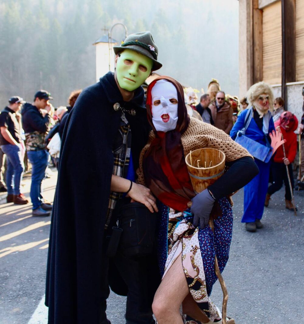 Il Barba con mantello, cappello e maschera verde e la Mèda con scialle, maschera bianca e cesto